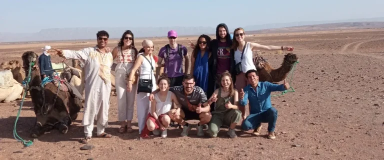 Grupo de viajeros con un dromedario en el desierto